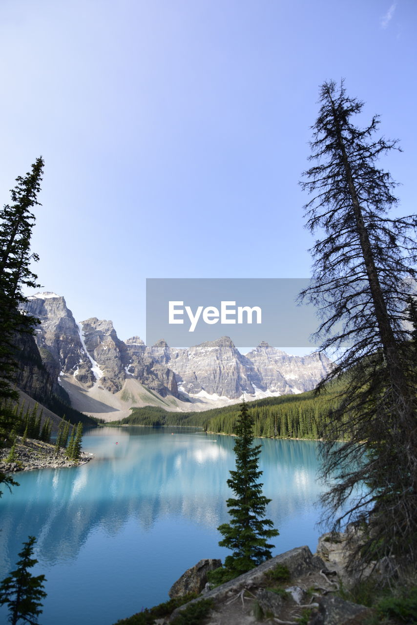 Scenic view of lake and mountains against blue sky