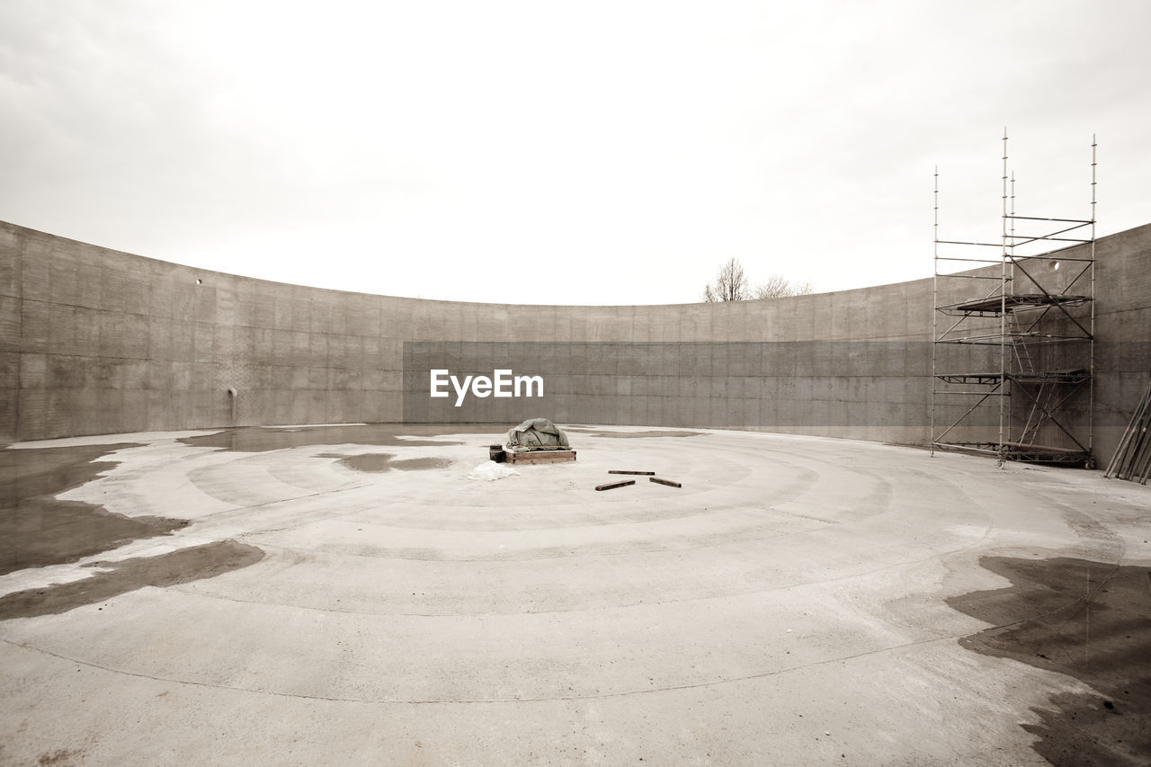 HIGH ANGLE VIEW OF SKATEBOARD IN PARK AGAINST BUILDING