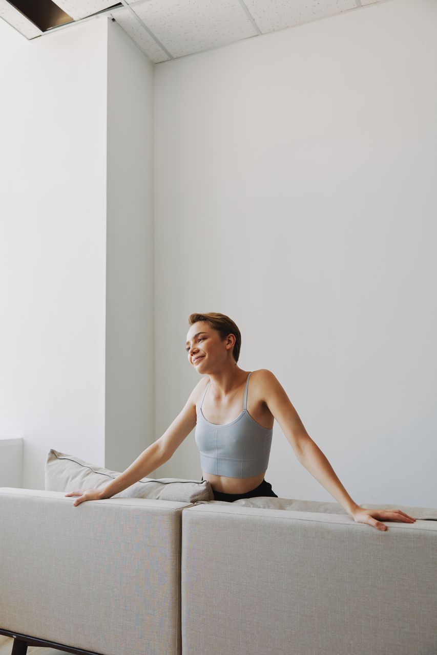 side view of young woman looking away while standing against wall