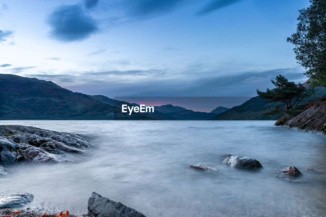 SCENIC VIEW OF SEA BY MOUNTAIN AGAINST SKY