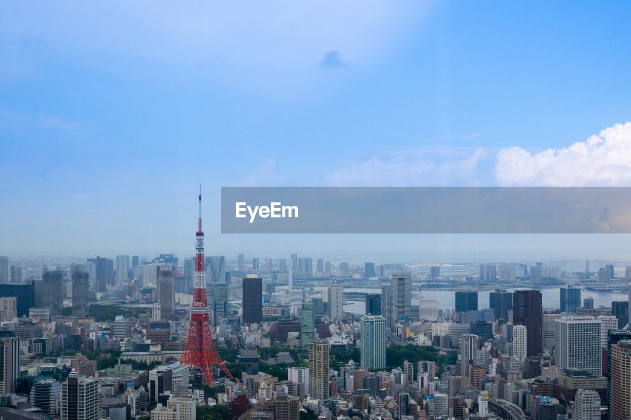 Tokyo tower amidst cityscape against sky