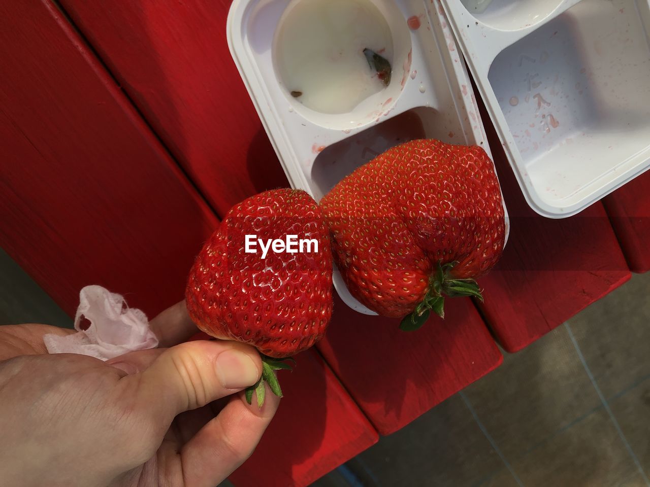 red, strawberry, hand, food and drink, food, one person, fruit, healthy eating, berry, holding, adult, wellbeing, freshness, indoors, produce, high angle view, plant, lifestyles, meal, close-up, women, table