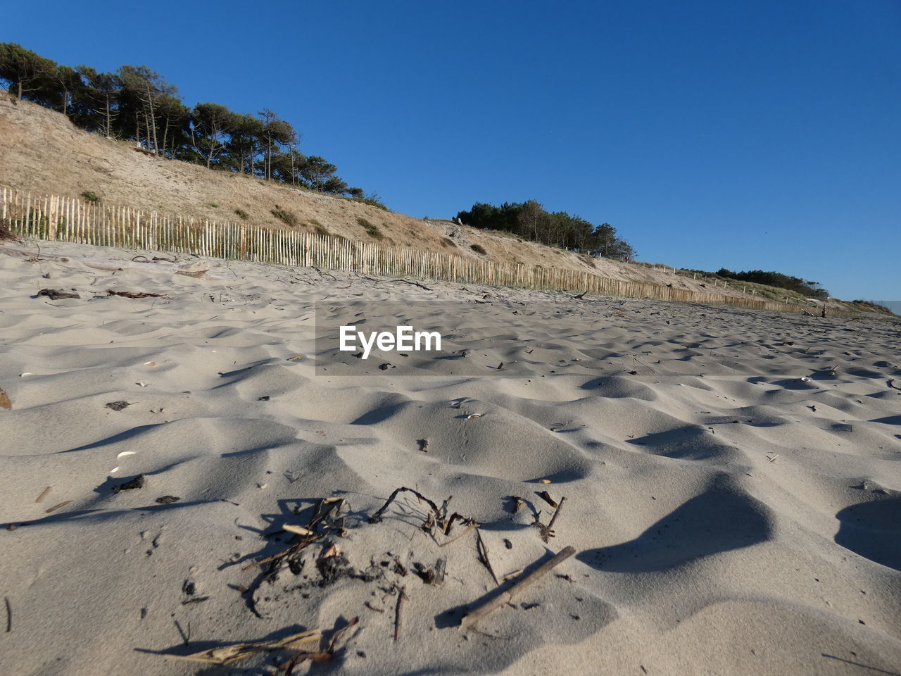 FOOTPRINTS ON SAND AGAINST CLEAR BLUE SKY