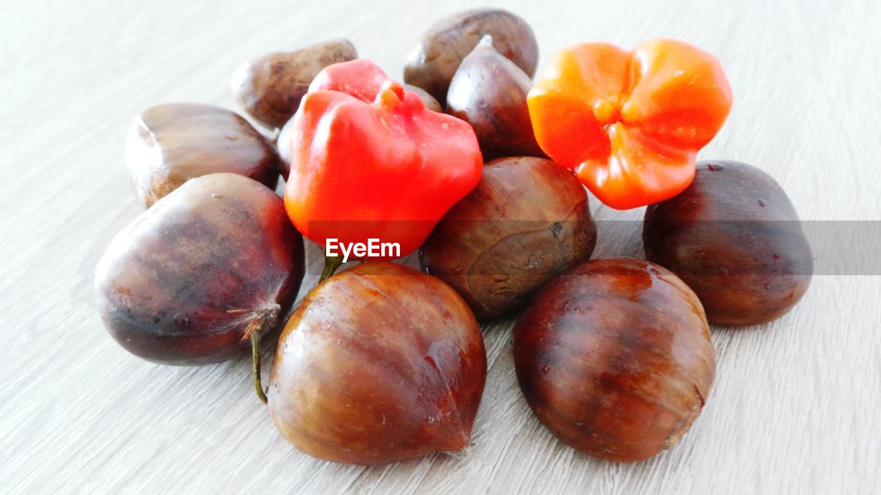 High angle view of chestnuts and chili peppers wooden table