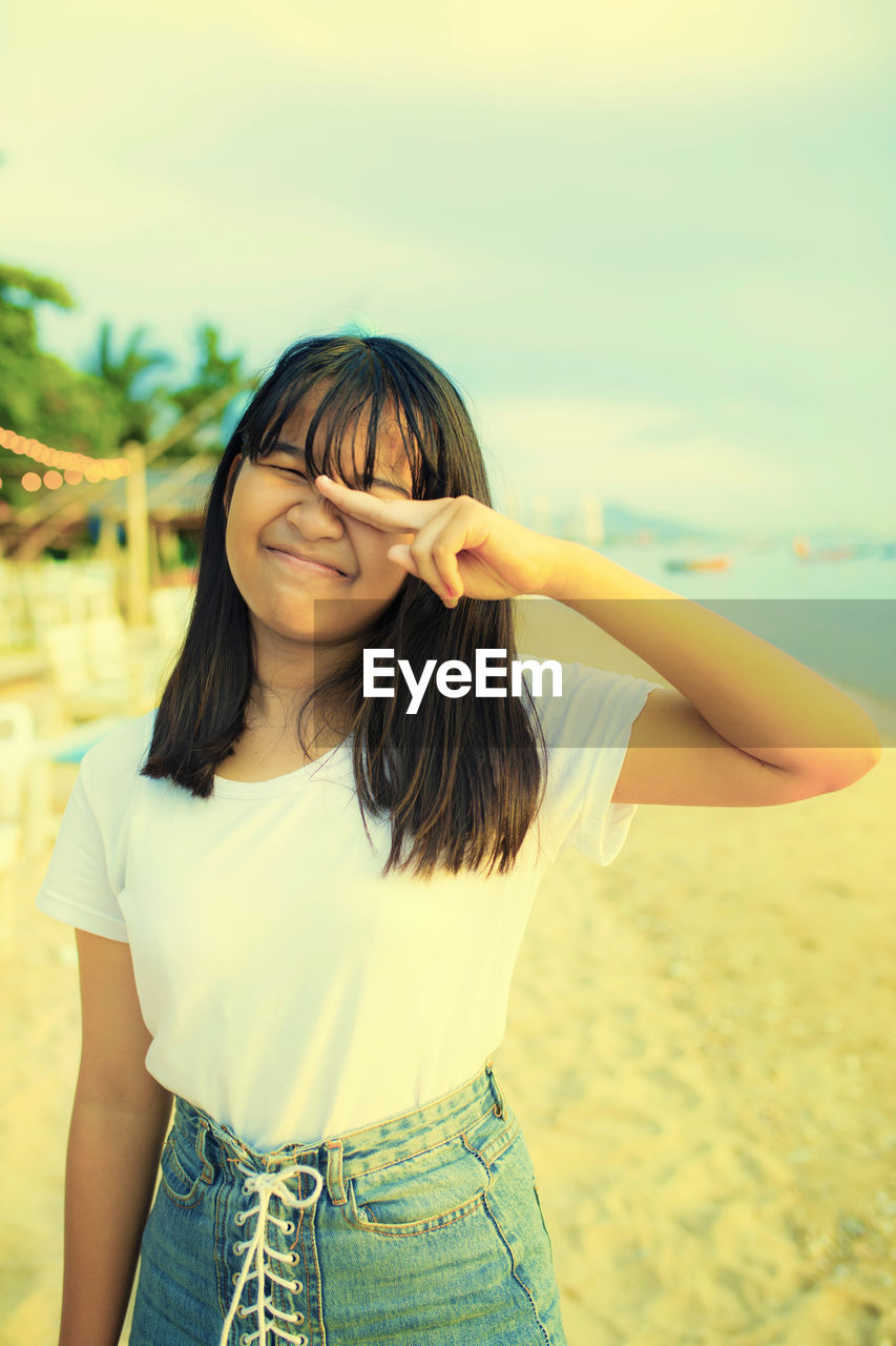 Girl with eyes closed standing at beach