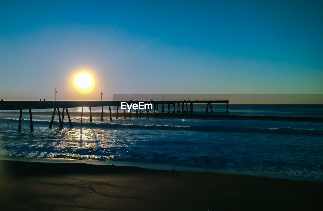 Scenic view of sea against clear sky at sunset