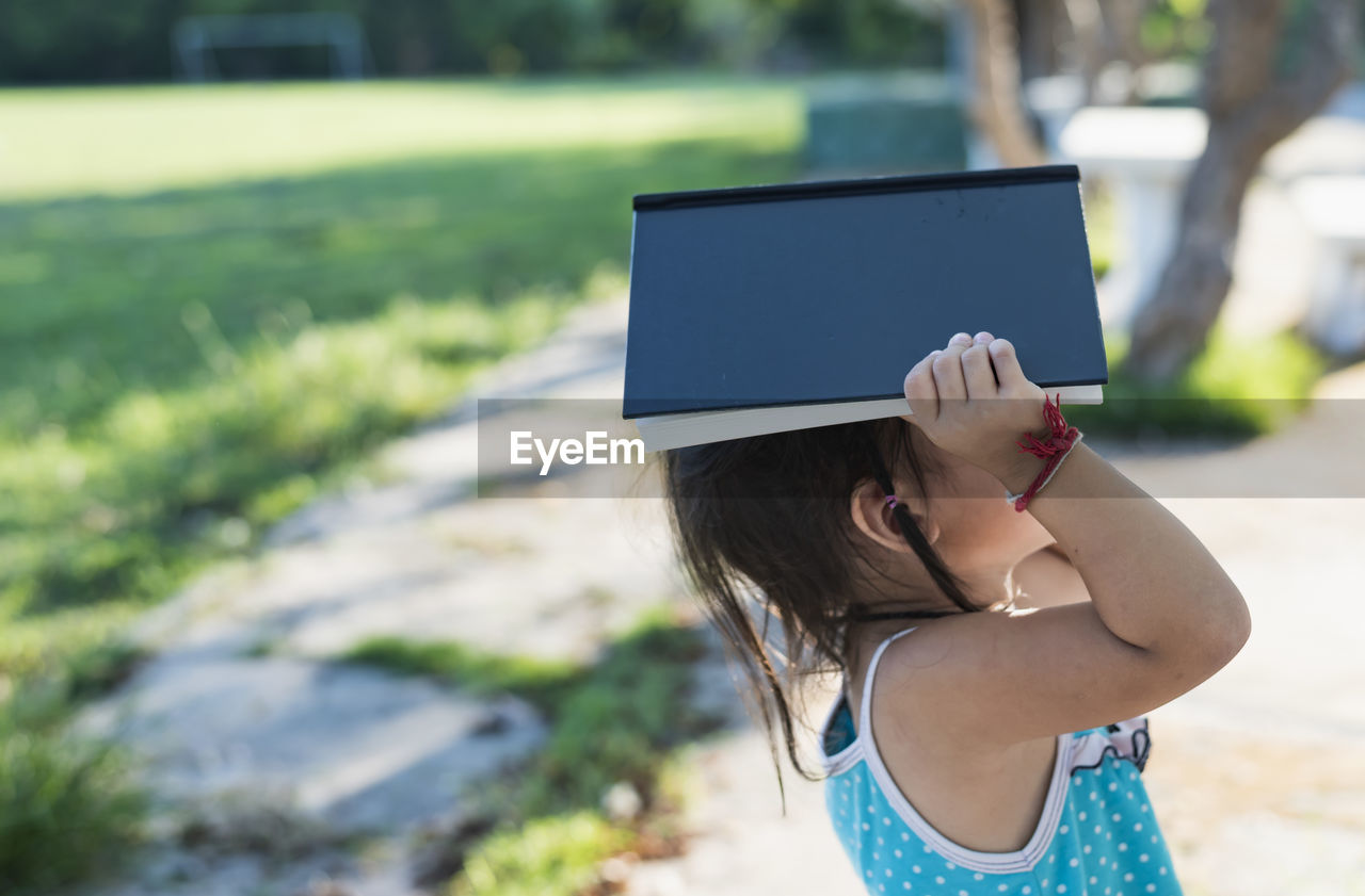 young woman using digital tablet while standing outdoors