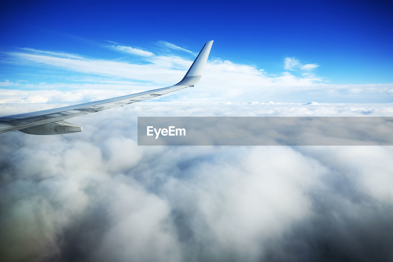 View of airplane wing and clouds in sky