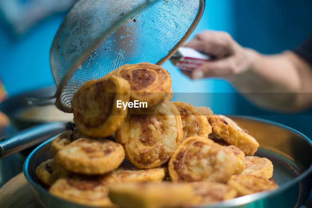 CLOSE-UP OF PERSON PREPARING FOOD IN KITCHEN