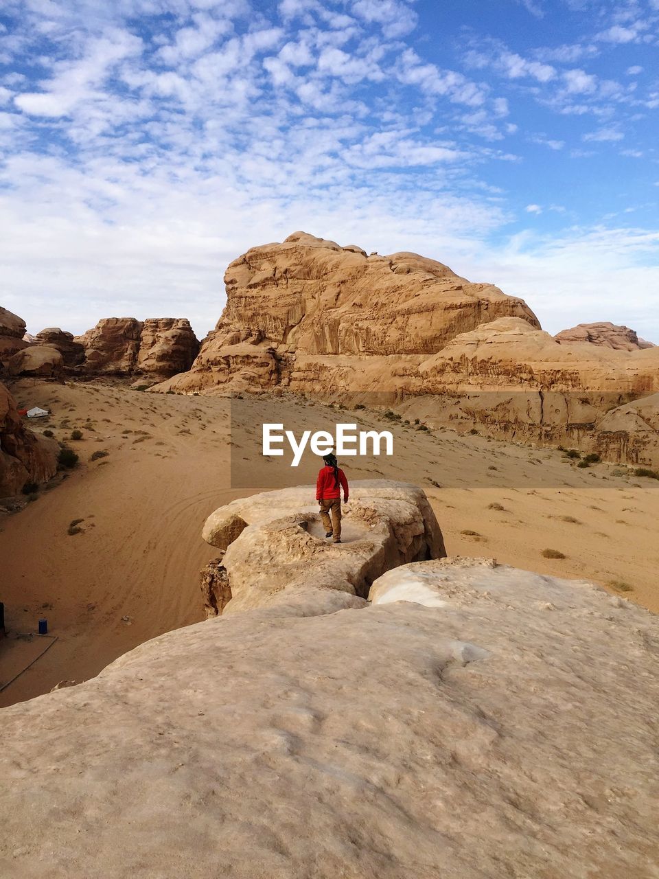 Man walking on rock against sky