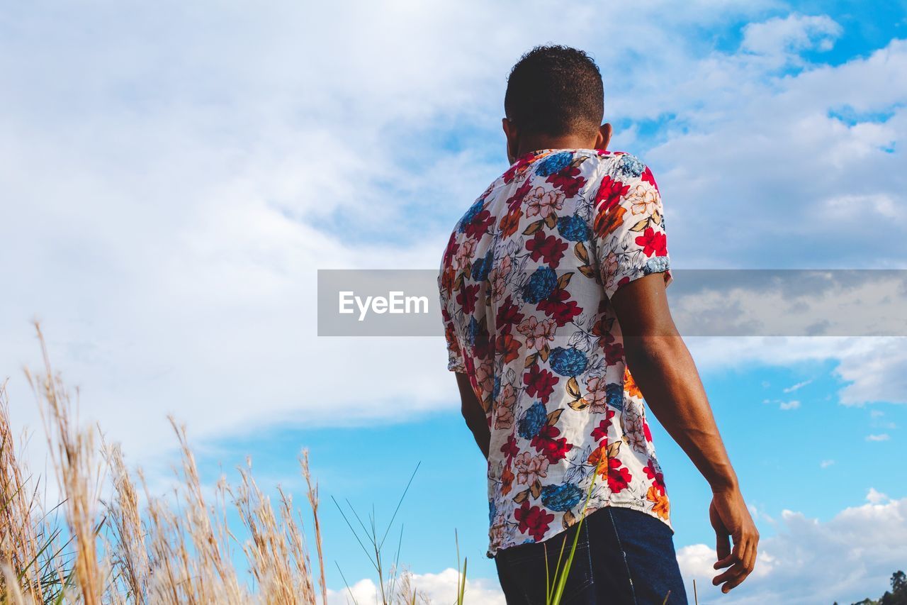 Rear view of a man looking sideways at the sky