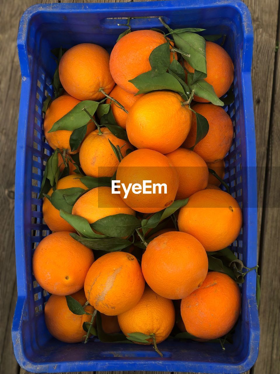 HIGH ANGLE VIEW OF ORANGES IN CRATE