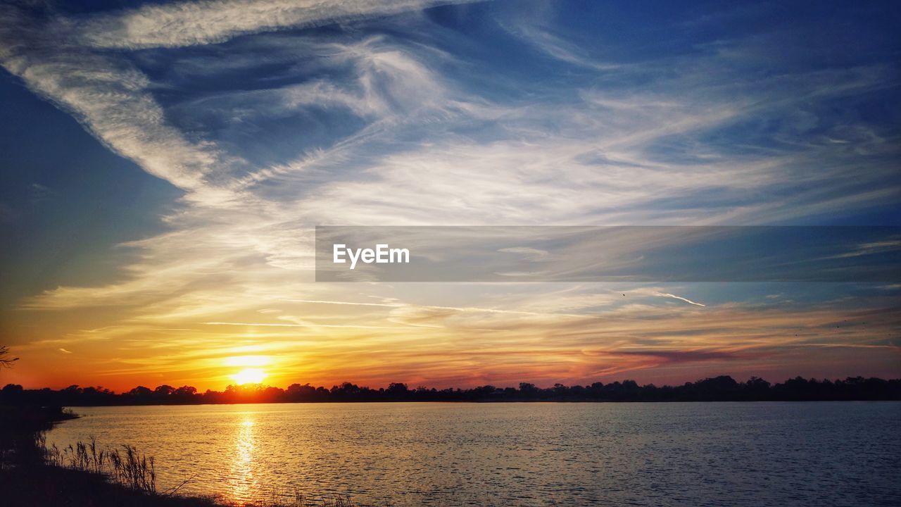 SCENIC VIEW OF SUNSET OVER LAKE