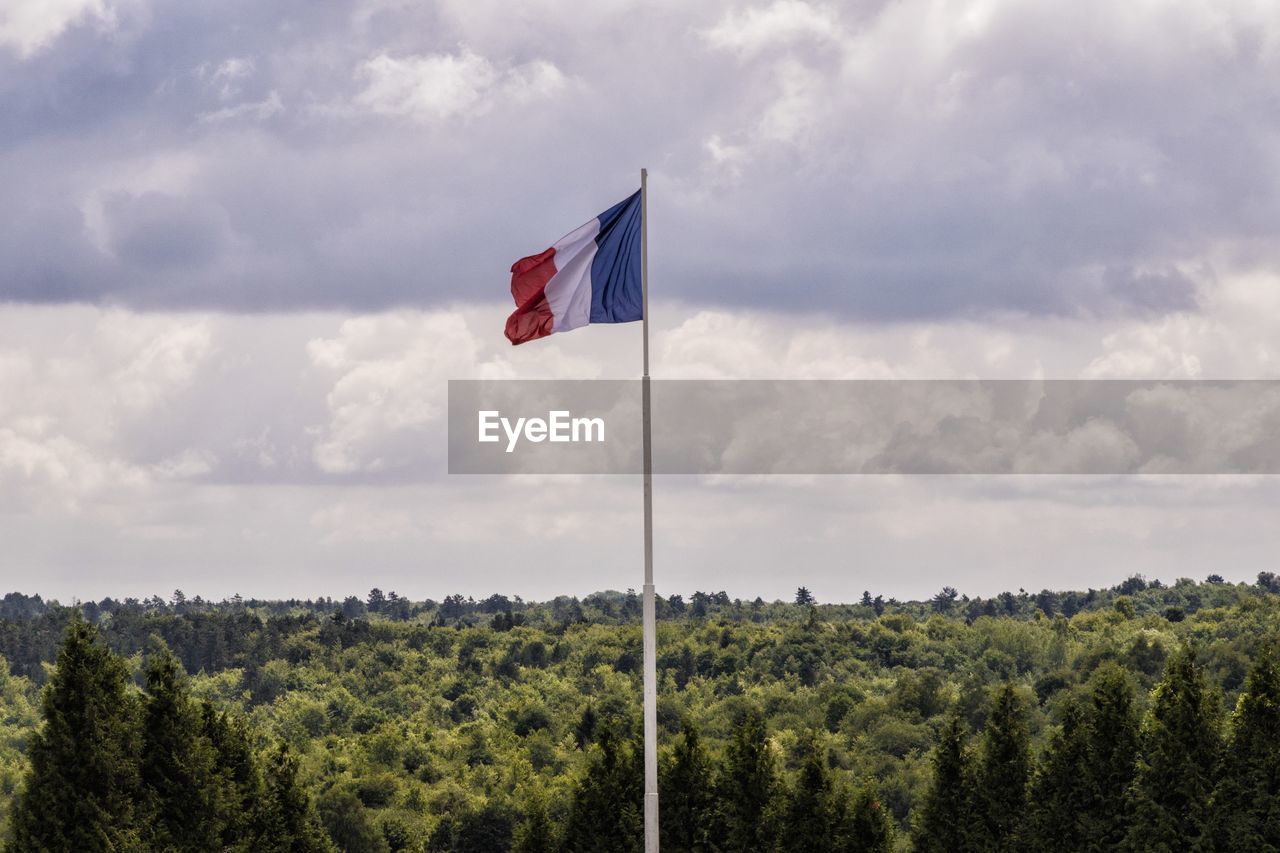 FLAG ON LANDSCAPE AGAINST SKY