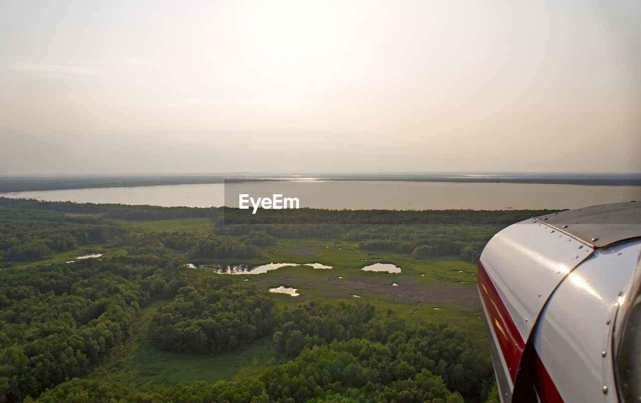 SCENIC VIEW OF LANDSCAPE AGAINST SKY SEEN THROUGH AIRPLANE