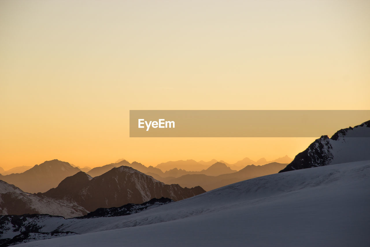 Scenic view of mountains against clear sky during sunset