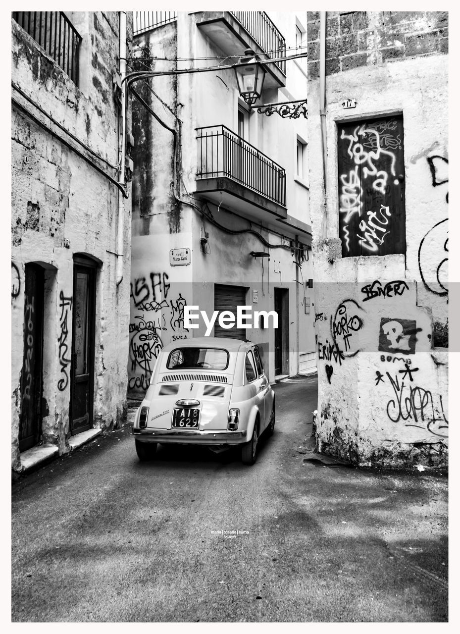 CARS ON STREET AMIDST BUILDINGS