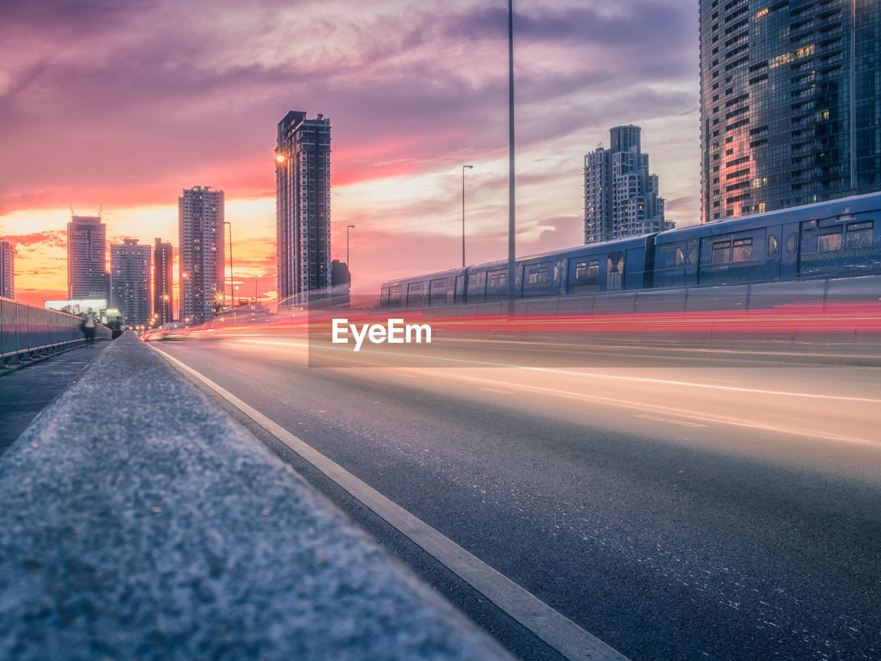 View of city street against sky during sunset