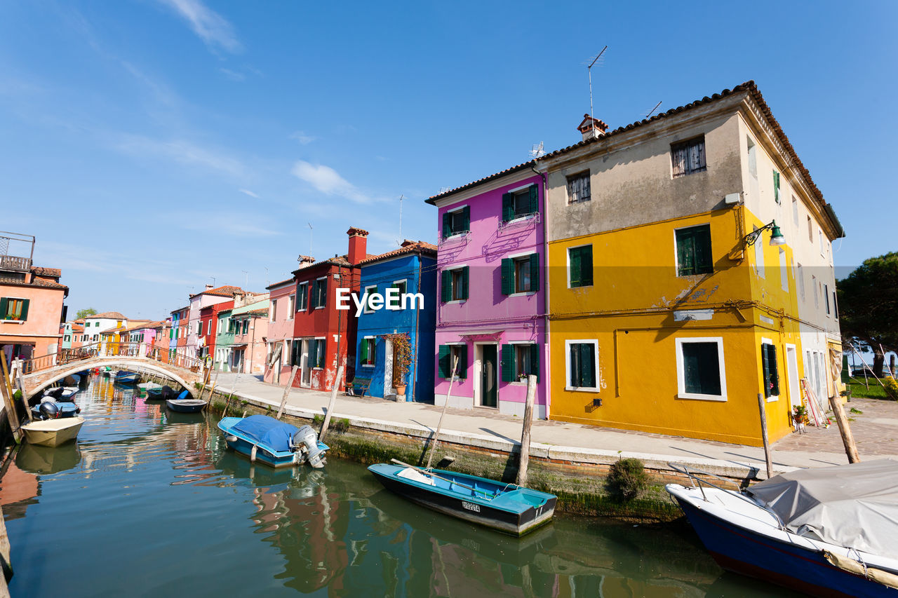 BOATS MOORED IN CANAL BY BUILDINGS IN CITY