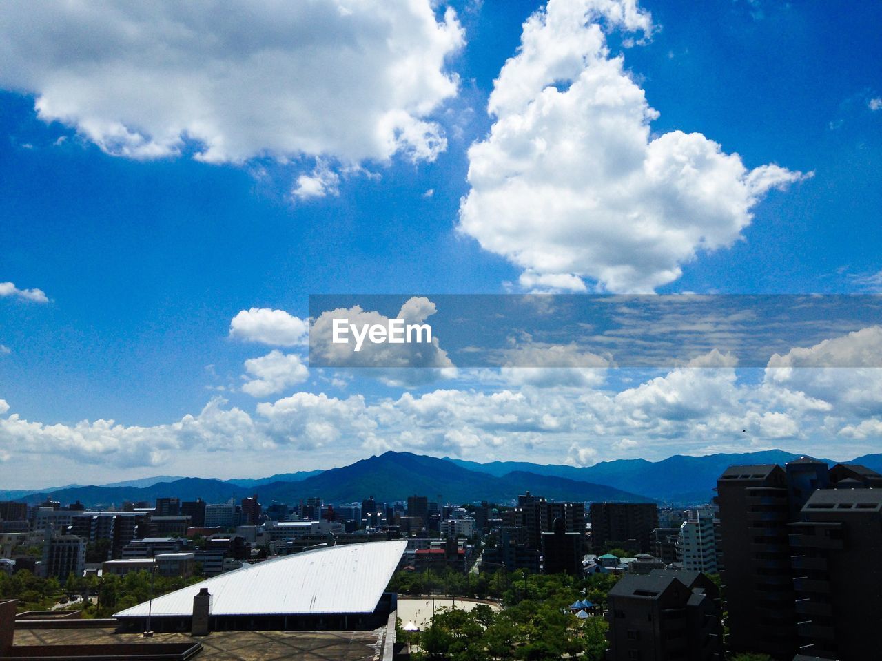 VIEW OF BUILDINGS AGAINST CLOUDY SKY