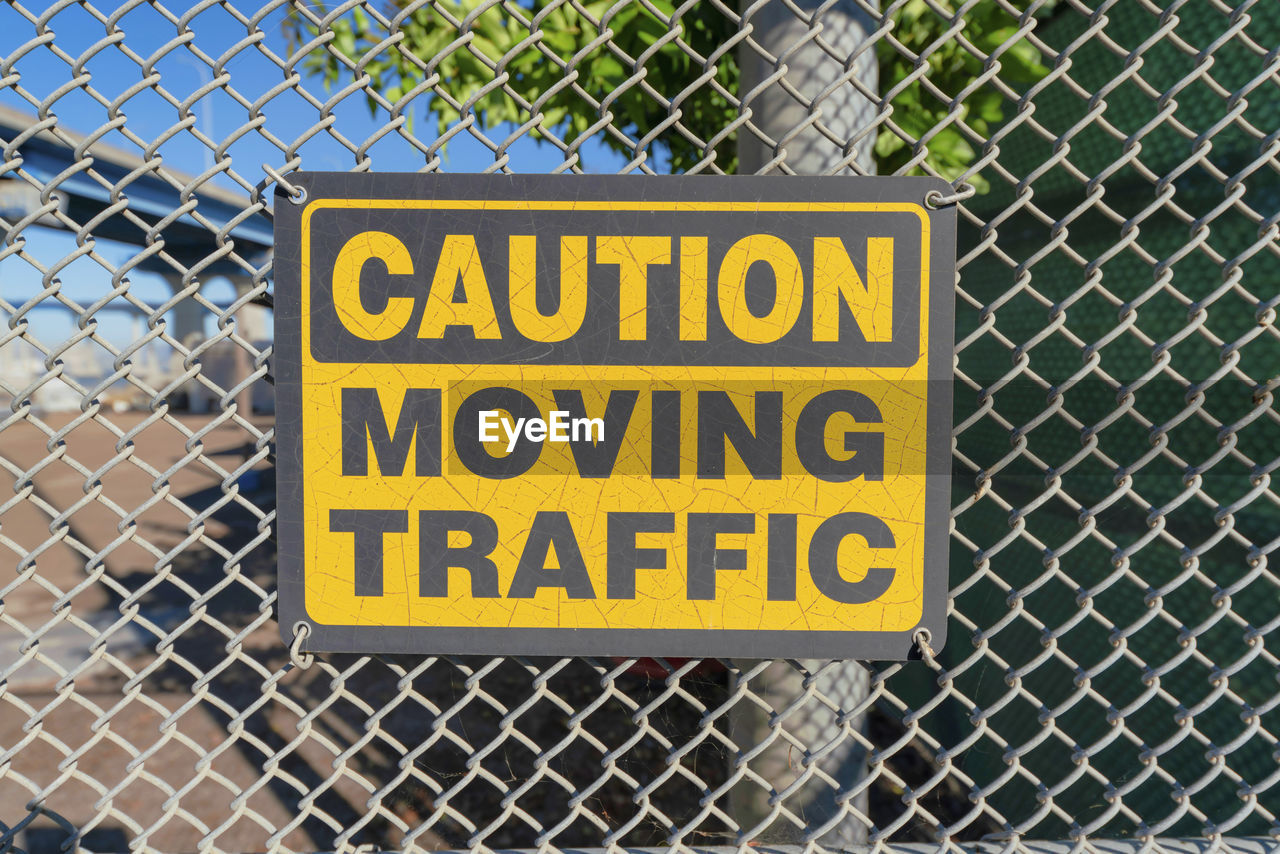 fence, communication, sign, chainlink fence, text, western script, security, warning sign, protection, chain-link fencing, signage, no people, metal, street sign, wire fencing, information sign, yellow, day, outdoors, forbidden, close-up