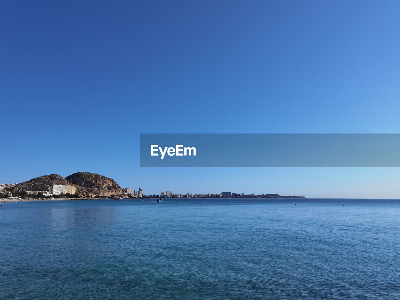 Scenic view of sea against clear blue sky