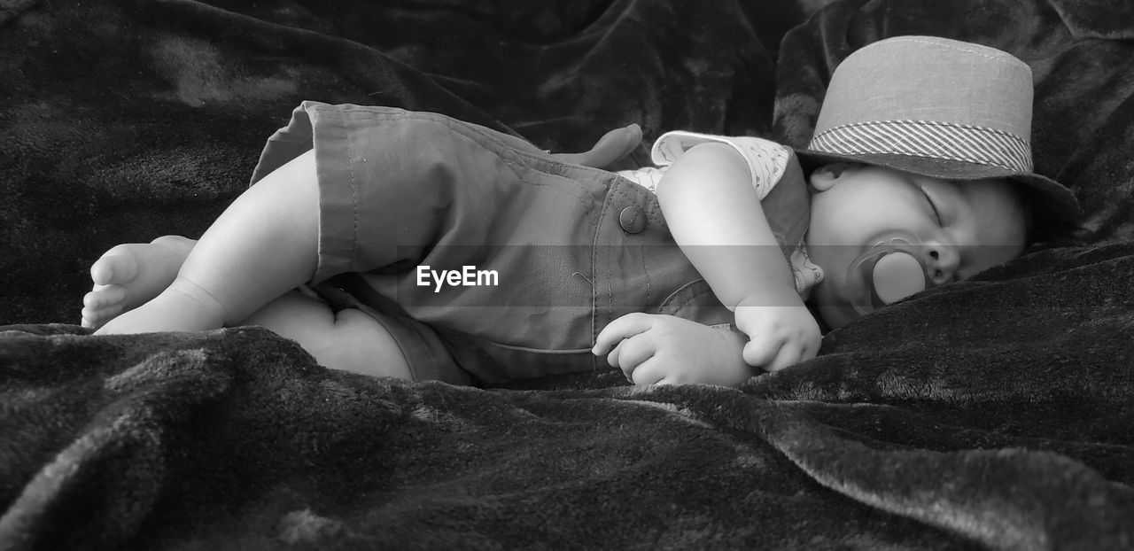 Close-up of baby boy sleeping on bed