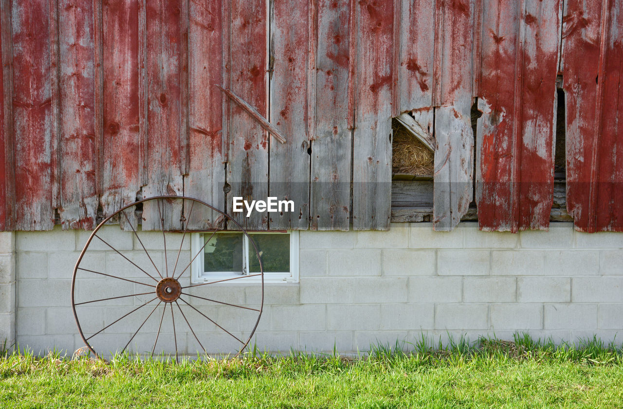 Rusty metal on field against building