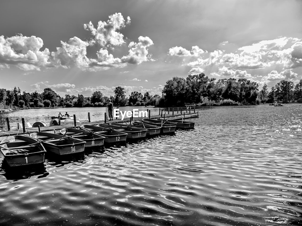 BOATS MOORED AT LAKE AGAINST SKY