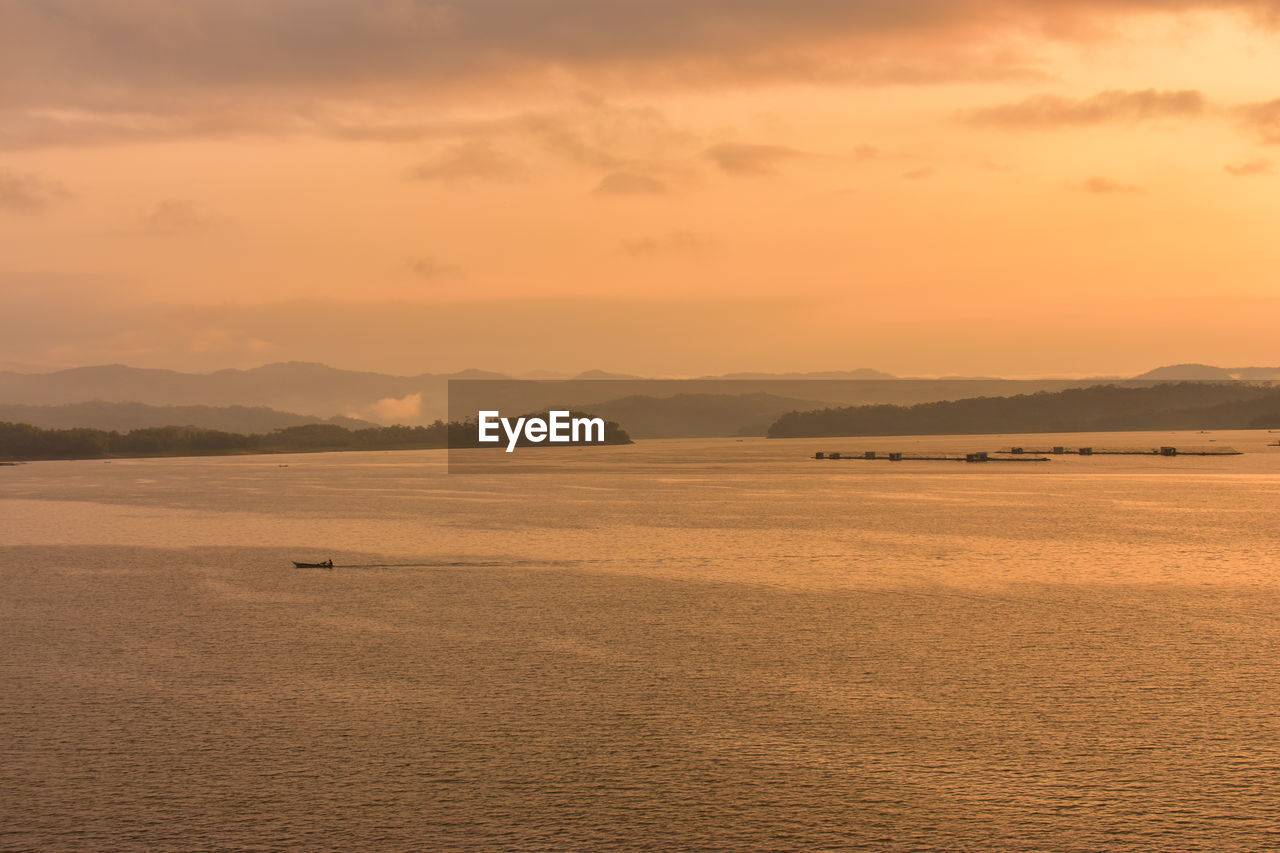 Scenic view of lake against sky during sunrise