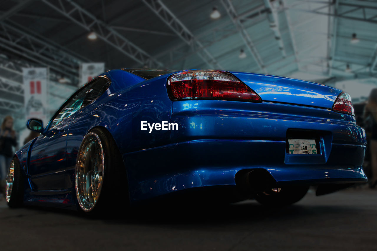 SIDE VIEW OF CAR PARKED AGAINST BLUE BACKGROUND