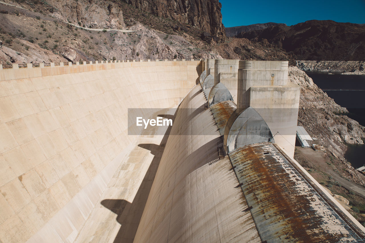 Hoover dam by mountain during sunny day