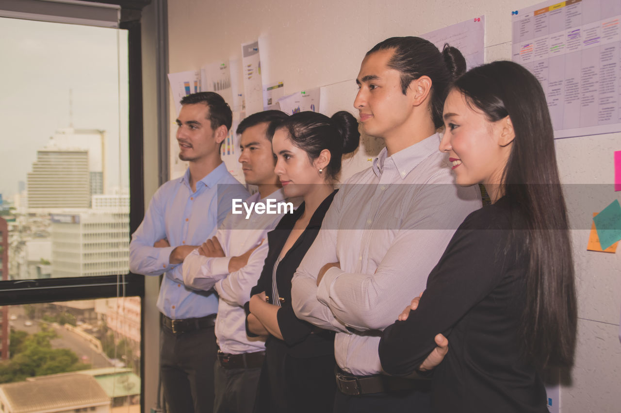 Colleagues standing in office during meeting