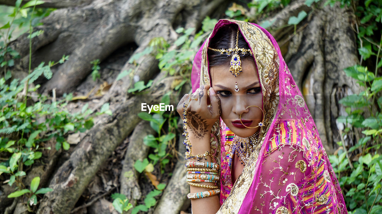 Close-up of bride wearing traditional costume in forest