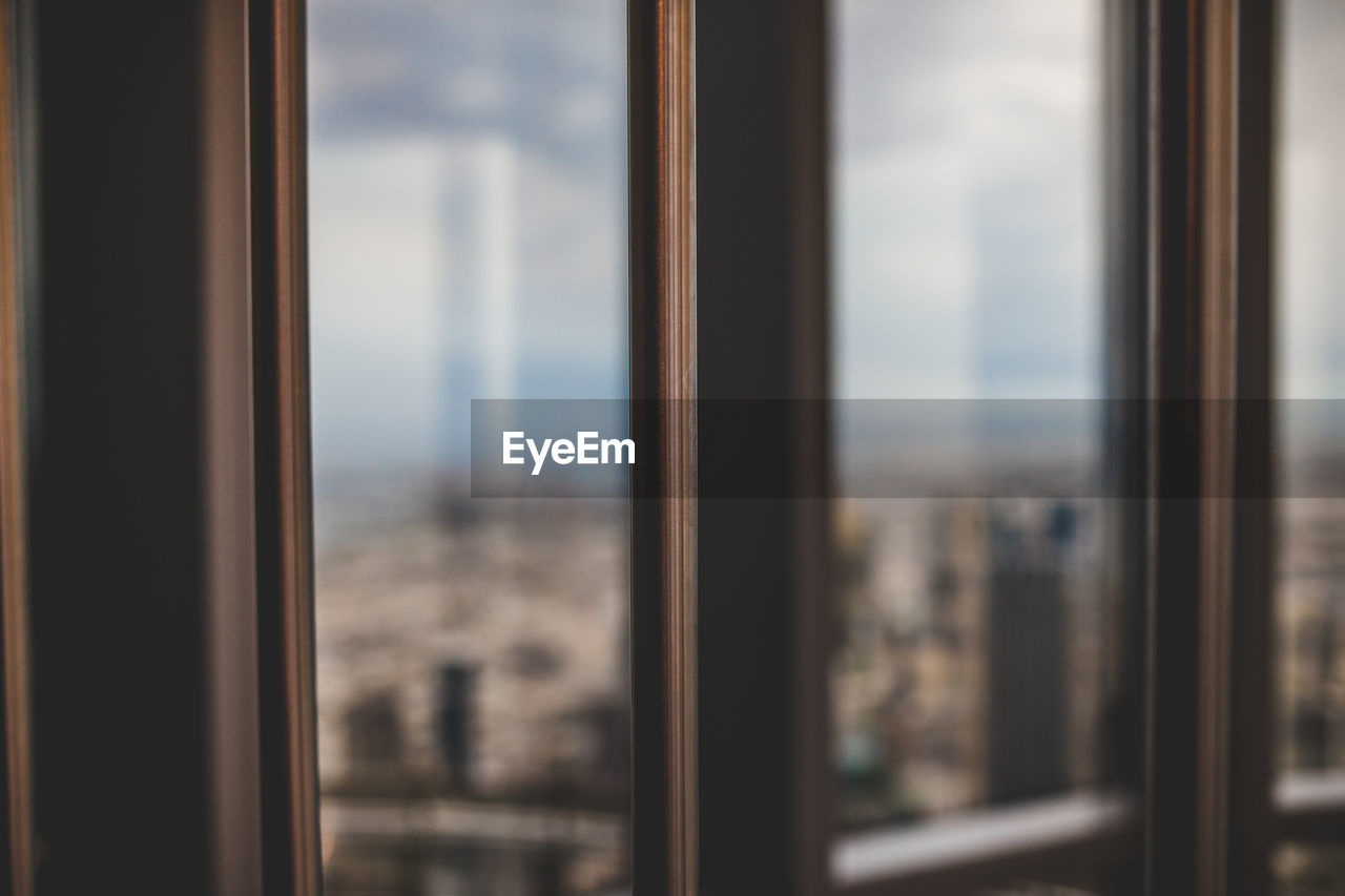 CLOSE-UP OF GLASS WINDOW AGAINST SKY