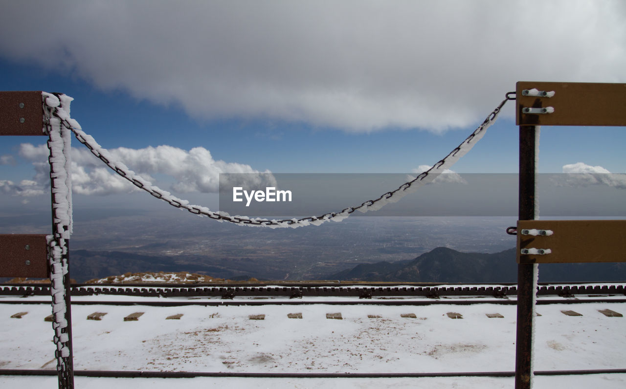 sky, cloud, winter, snow, nature, mountain, cold temperature, architecture, no people, scenics - nature, reflection, landscape, environment, blue, day, outdoors, beauty in nature, water, travel destinations, fence, bridge, morning, built structure, tranquility, land, tranquil scene, security, wind, travel, metal, transportation, protection