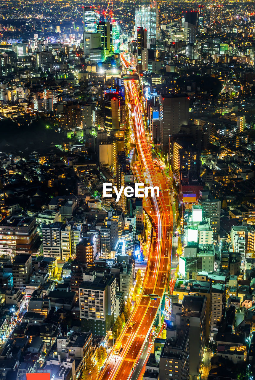 High angle view of illuminated street amidst buildings at night