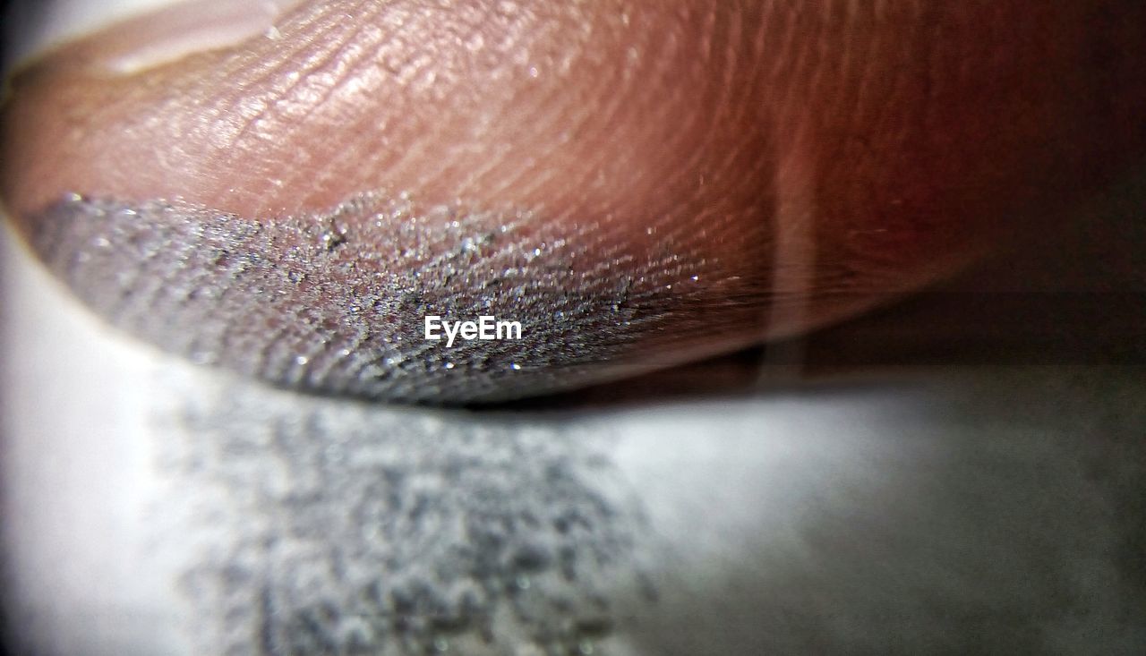 Extreme close-up of finger with silver color powder