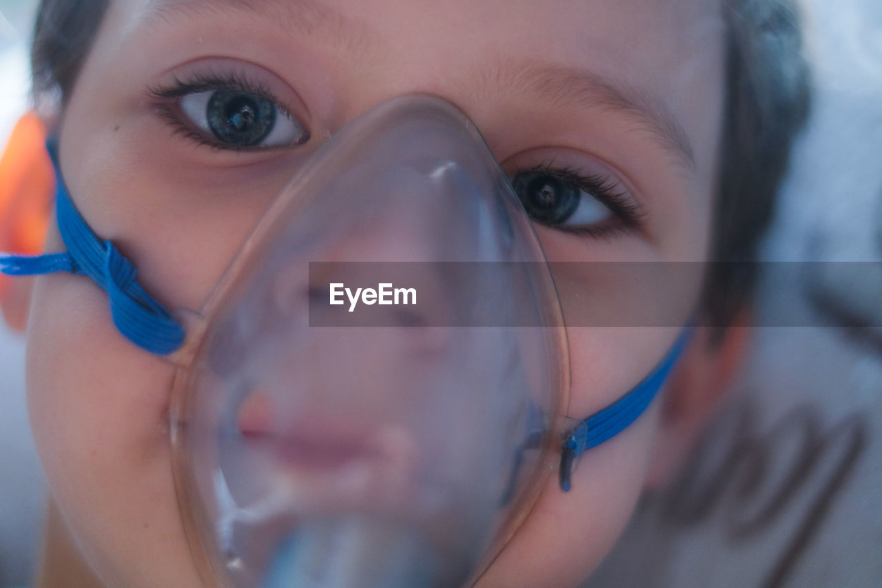 Close-up portrait of boy wearing oxygen mask