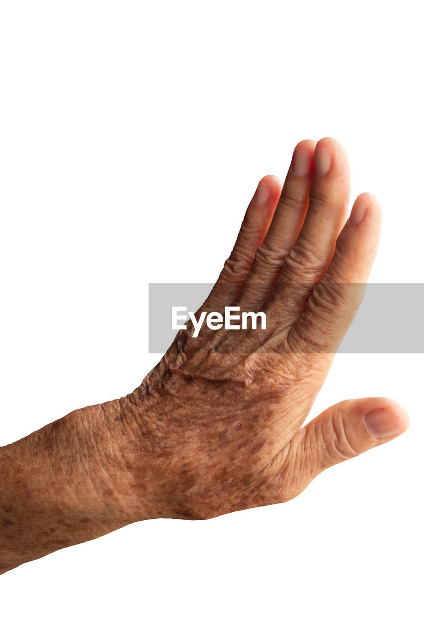 CLOSE-UP OF HUMAN HAND OVER WHITE BACKGROUND