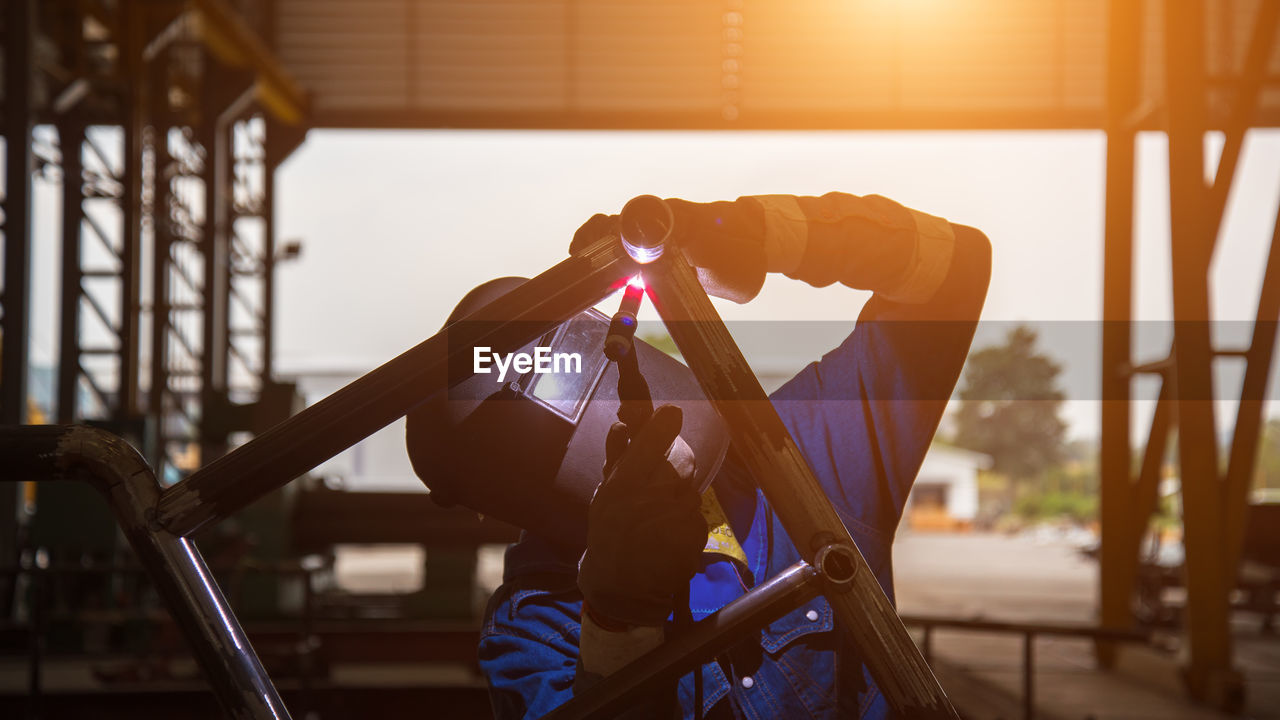 Worker welding metal in workshop