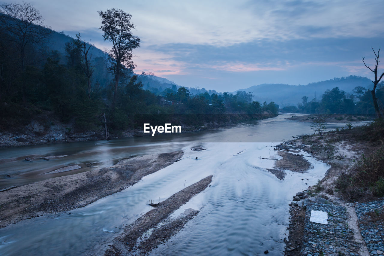 Scenic view of river by snowcapped mountains against sky