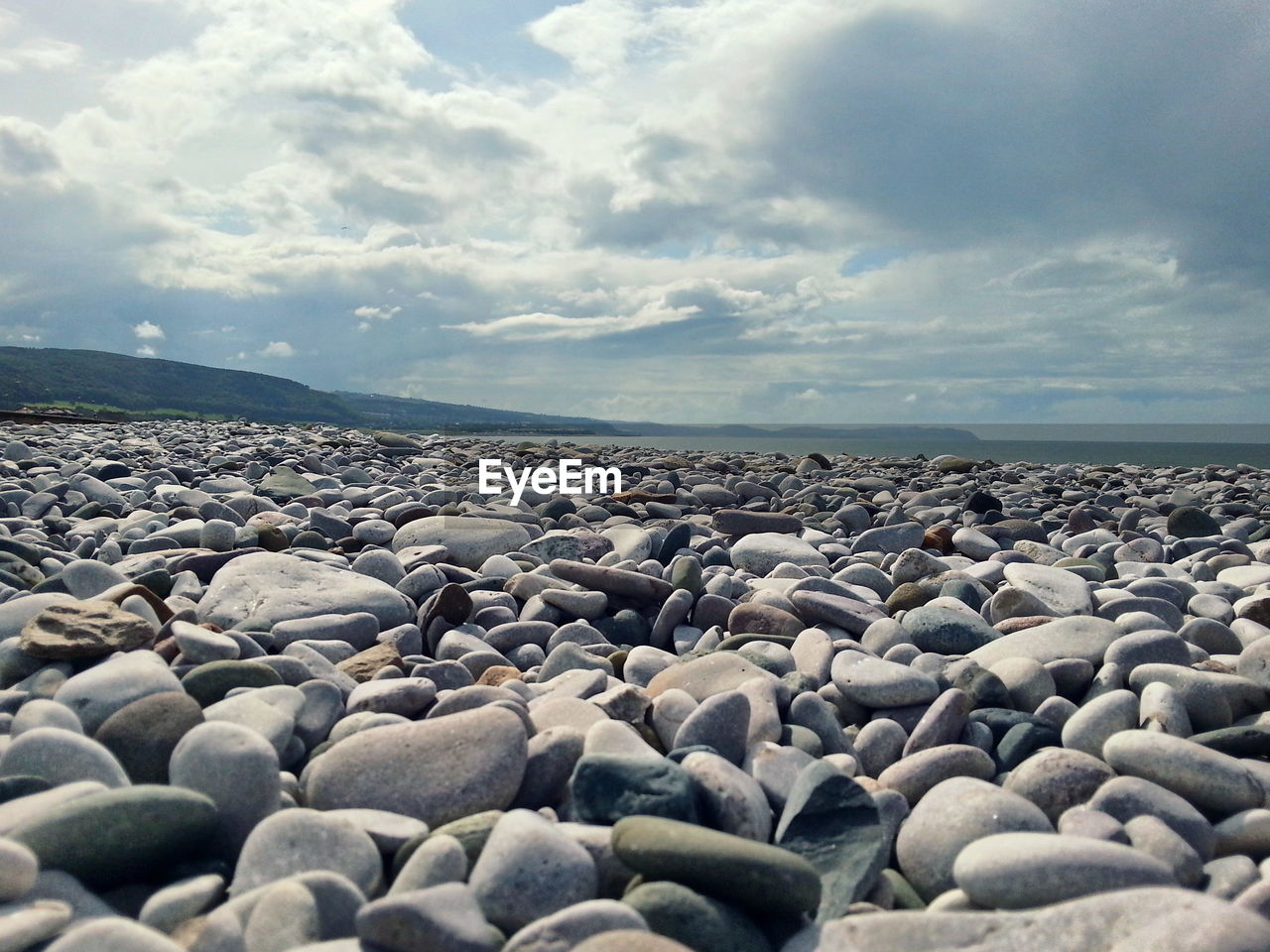 Surface level of pebble beach below clouds