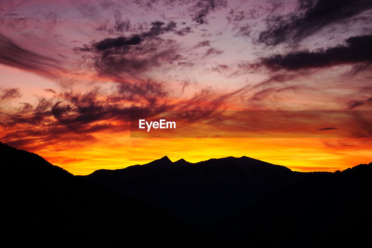 SCENIC VIEW OF DRAMATIC SKY OVER SILHOUETTE MOUNTAINS