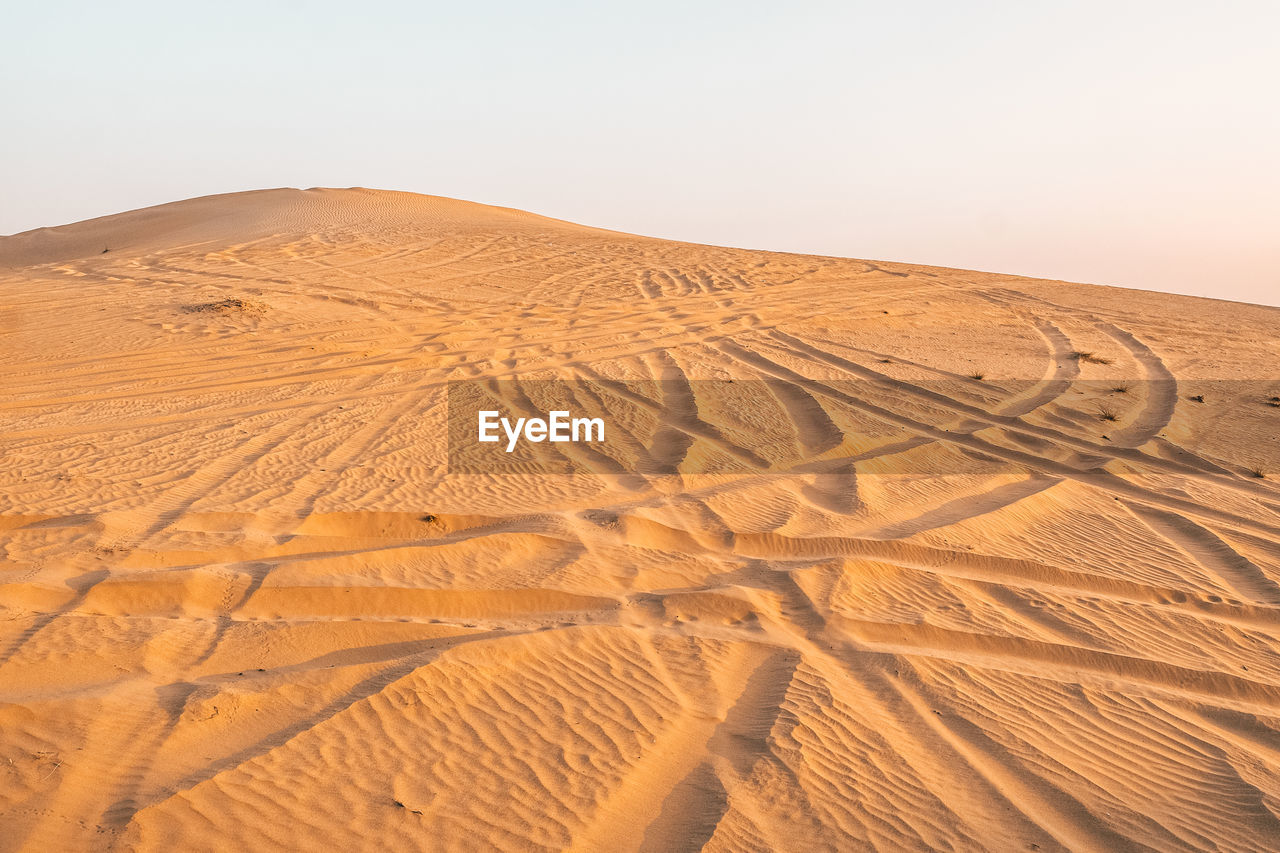 Sand dune in desert against clear sky