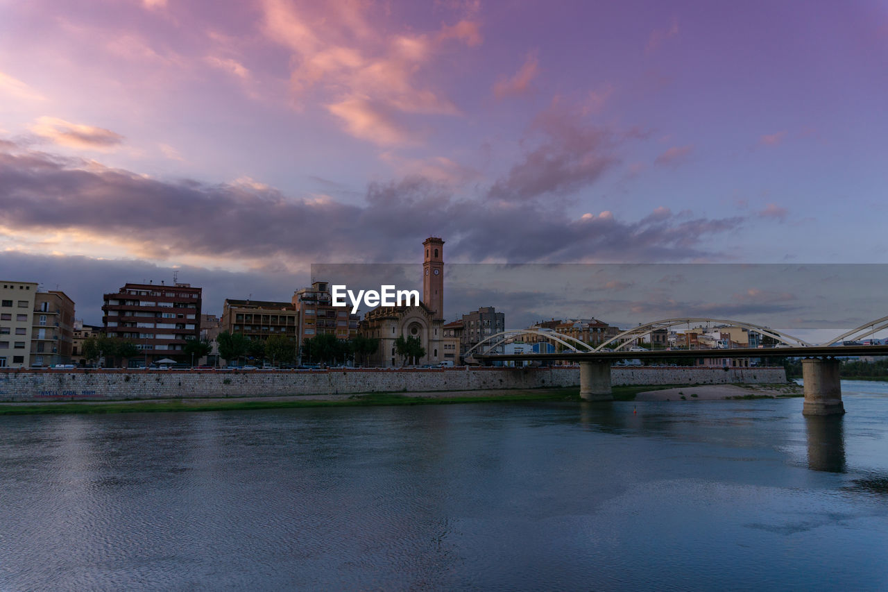 Bridge over river against buildings in city