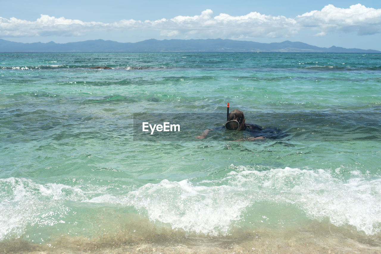 MAN ON SEA AGAINST SKY