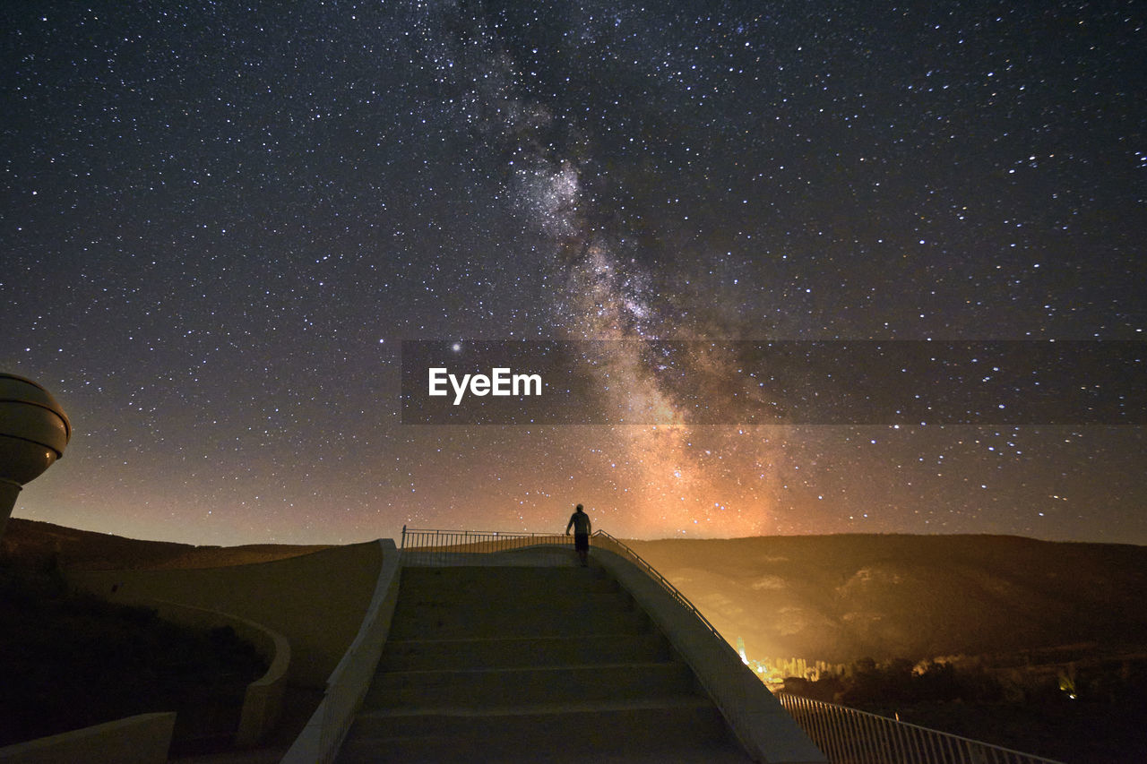 Person on grand staircase watching the milky way, stars, night time, long exposure