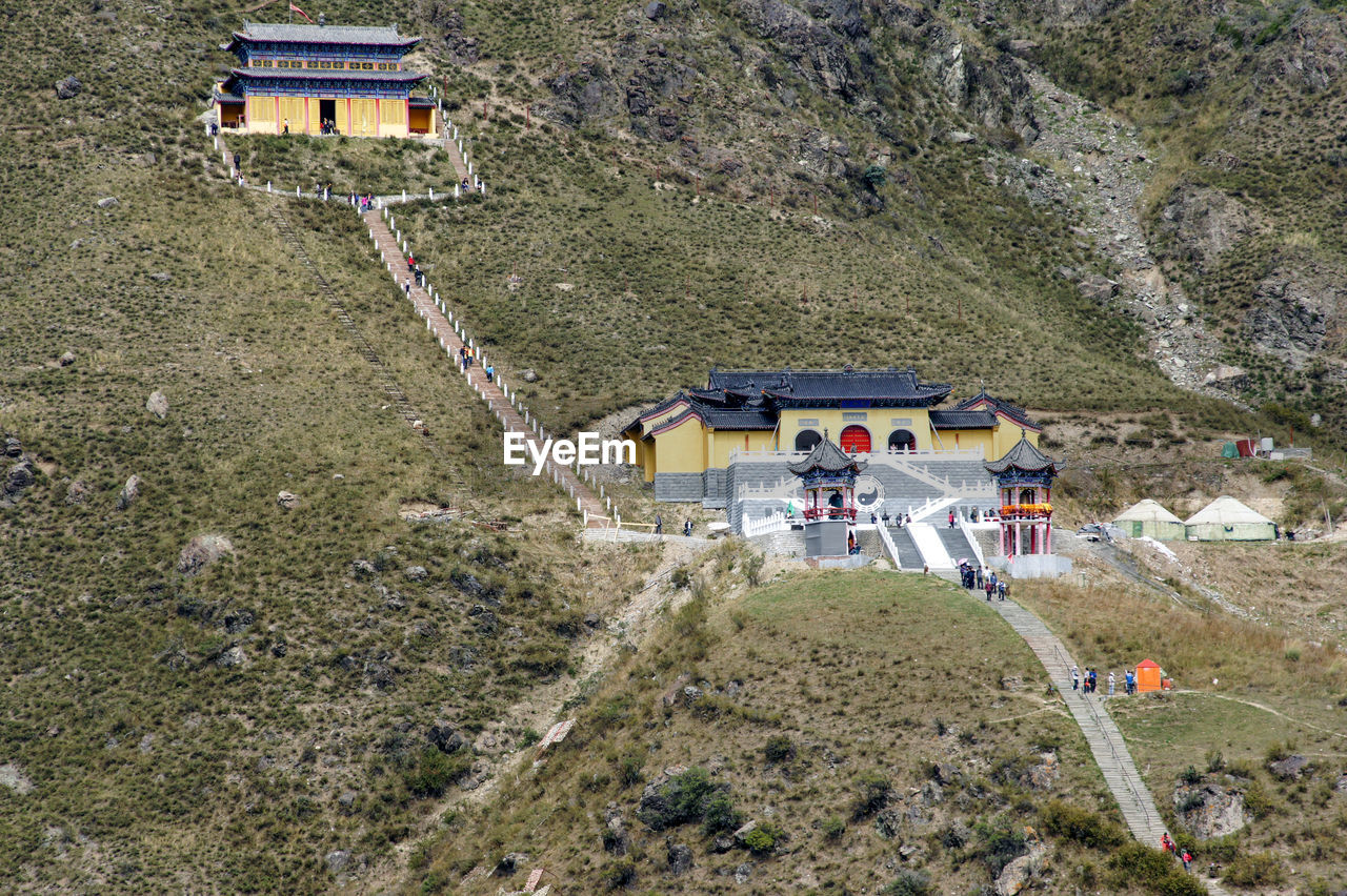 Buddhist temples and high angle view of visitors on stairs.