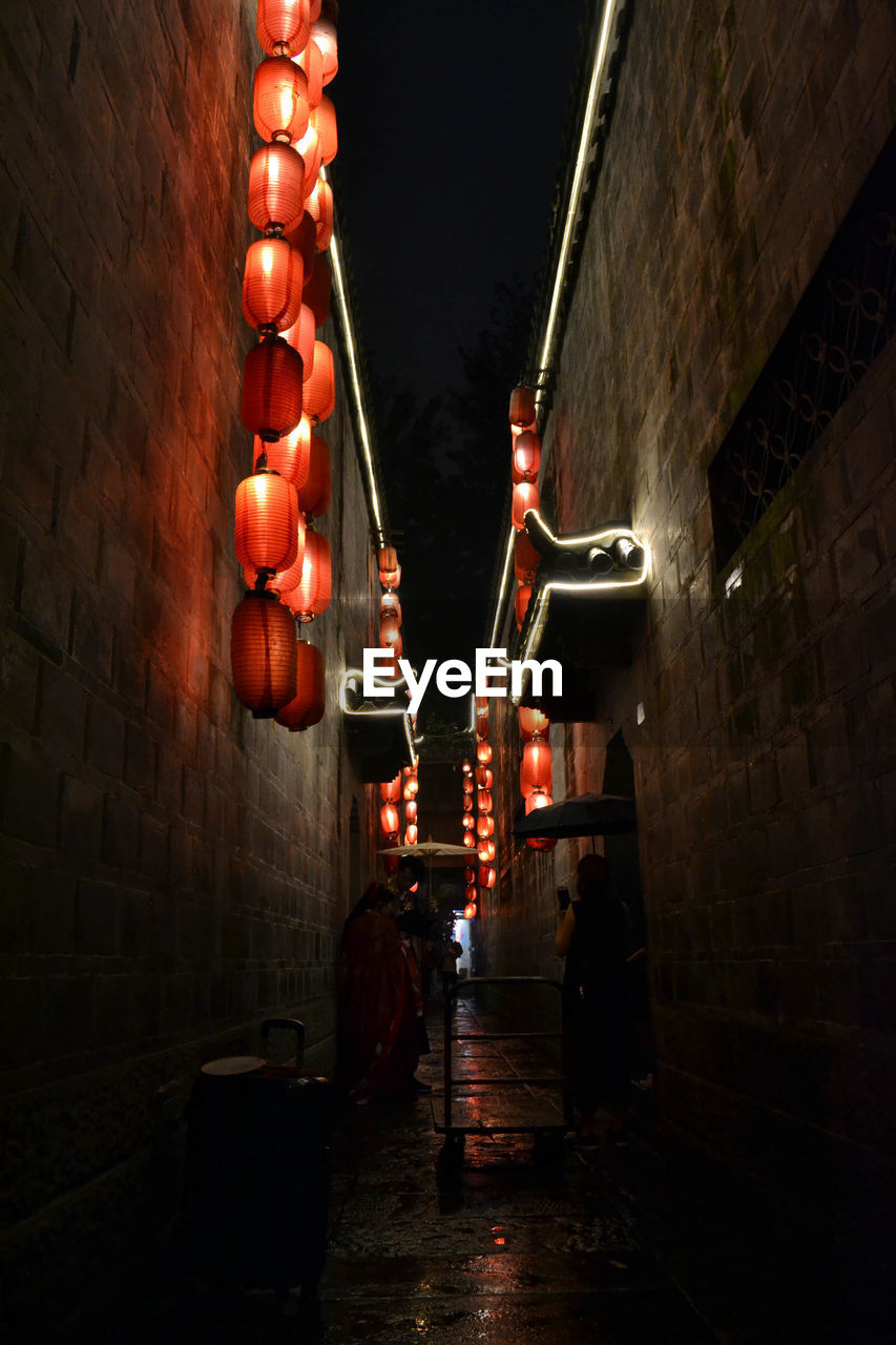 LOW ANGLE VIEW OF ILLUMINATED LIGHTS ON FOOTPATH